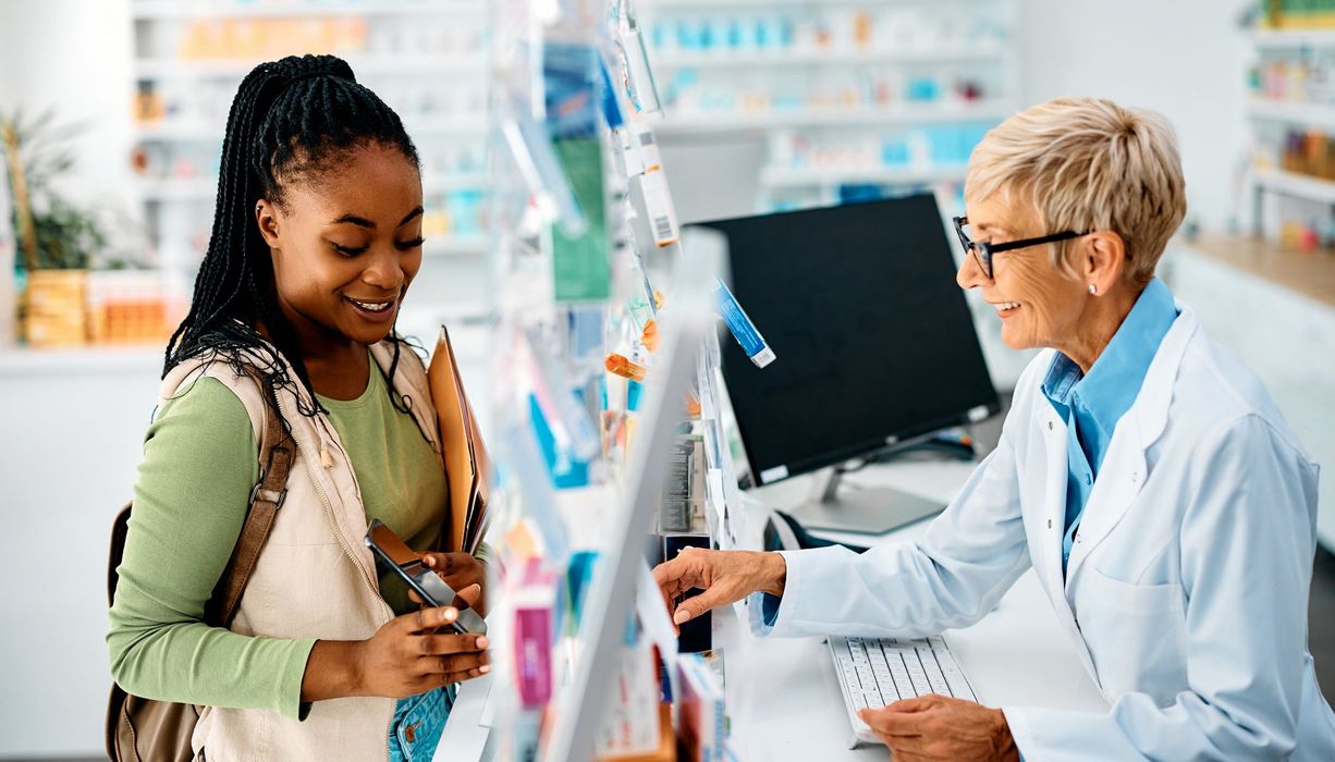 Frau zeigt Apothekerin ihr Smartphone.