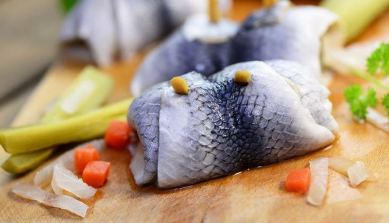 Rollmops auf Holzbrettchen