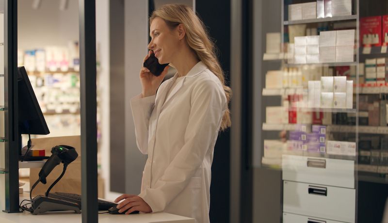 Apothekerin telefoniert im Notdienst.