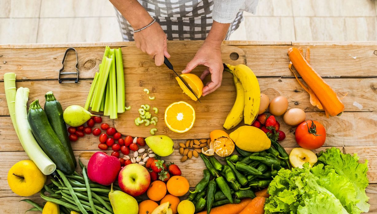 Buntes Obst und Gemüse auf einem Holztisch.