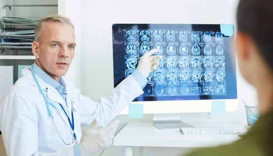 Arzt zeigt Patientin Bilder von MRT-Scans.