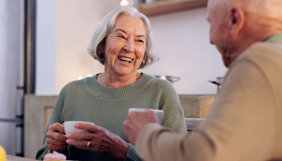 Ältere Frau und älterer Mann halten eine Kaffeetasse in der Hand