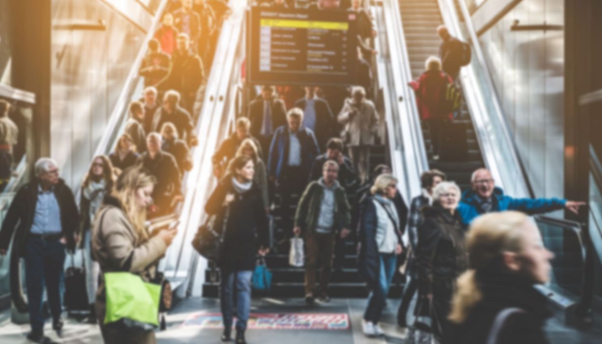 Szene im Bahnhof mit vielen Menschen.