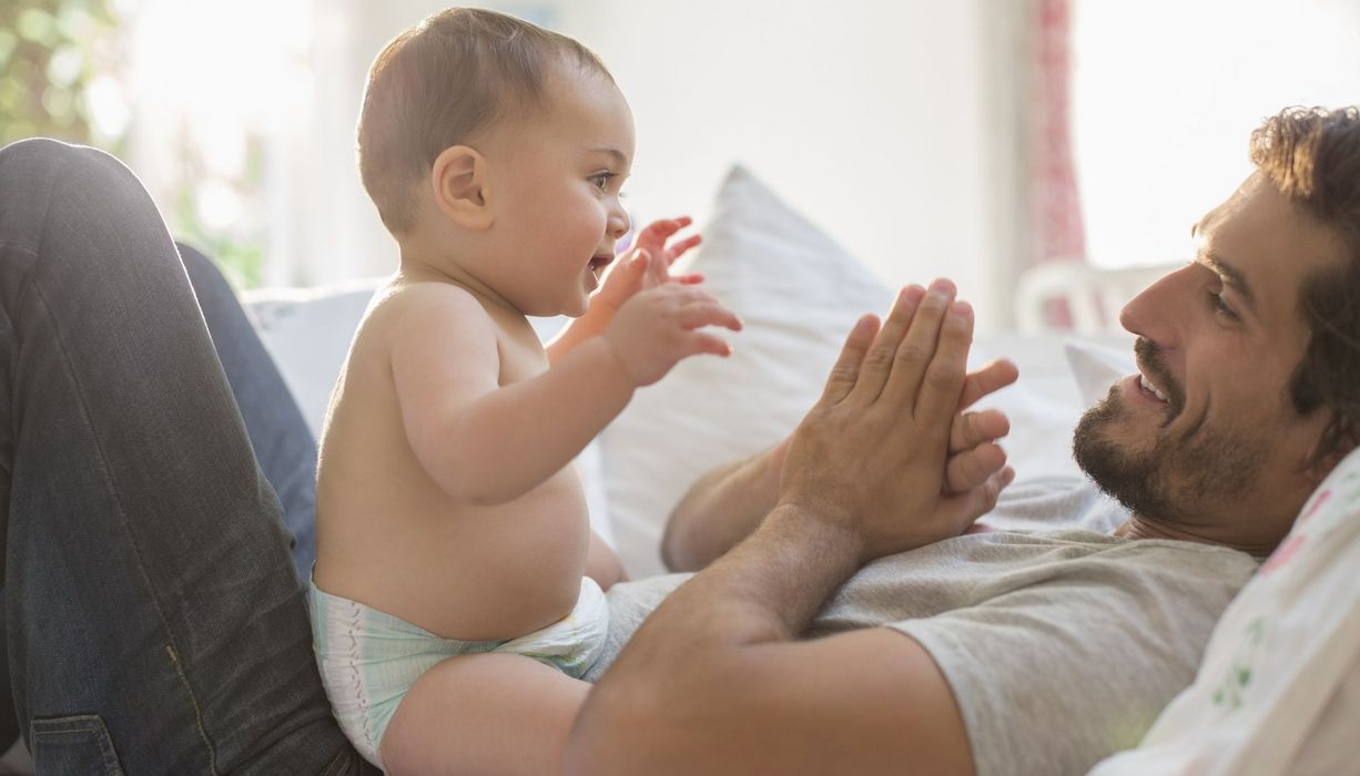 Vater, spielt mit seinem Baby.