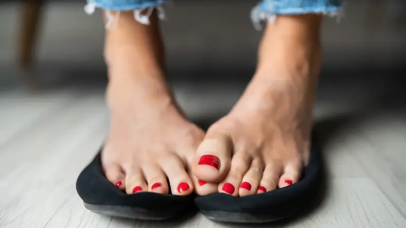 Füße mit rot lackierten Nägeln.