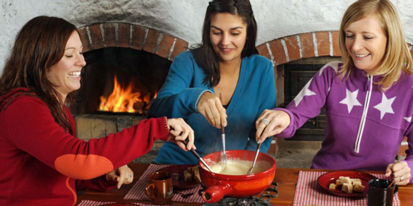 Drei junge Frauen beim Käse-Fondue