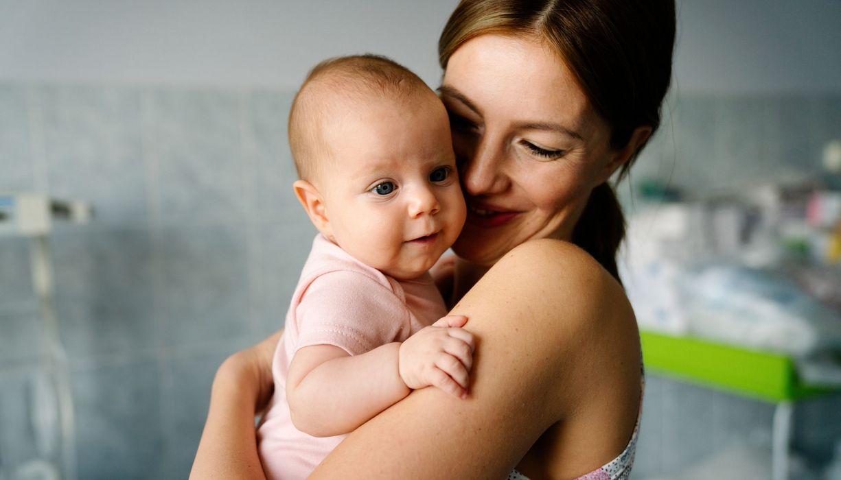 Junge Mutter, hält ihr Baby auf dem Arm.