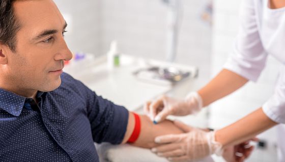 Mann bei der Blutabnahme beim Arzt.