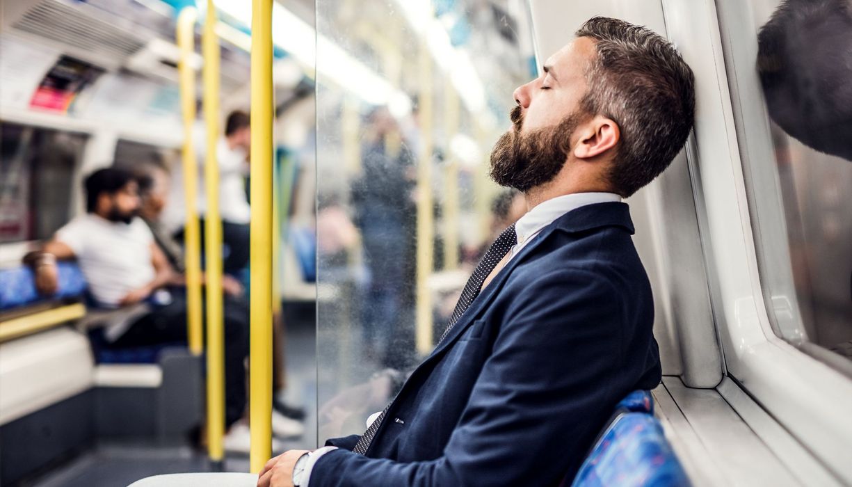 Mann, erschöpft in der Bahn.