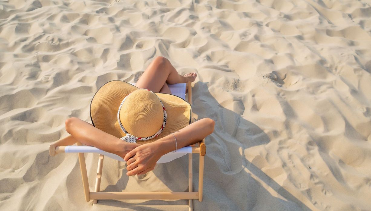 Junge Frau, sonnt sich am Strand.