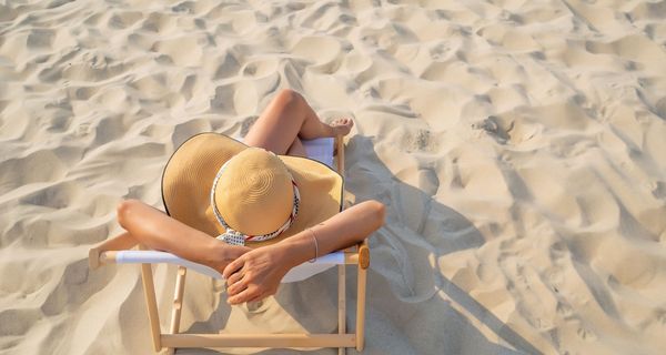 Junge Frau, sonnt sich am Strand.