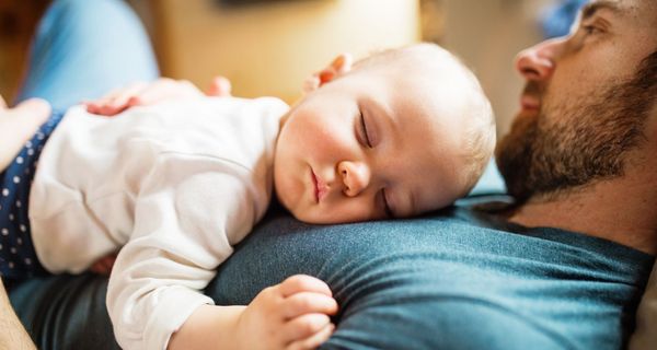 Baby, liegt bei seinem Vater auf der Brust.