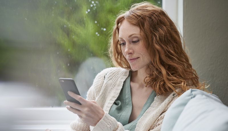 Frau, schaut auf ihr Smartphone.