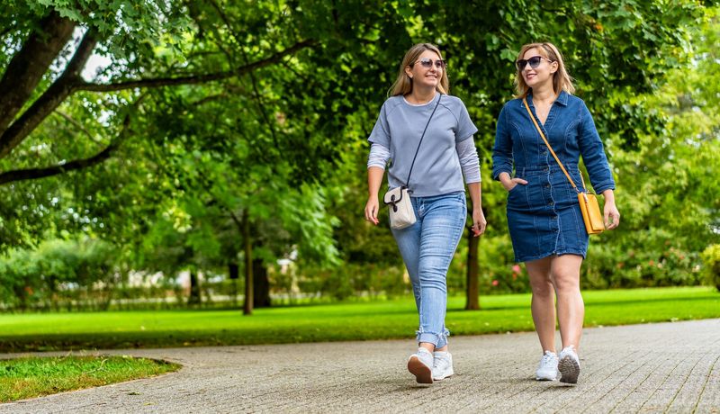 Zwei Frauen gehen im Park spazieren.