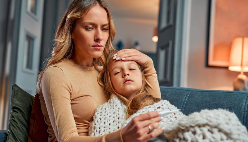 Mutter misst Fieber bei ihrem Kind.
