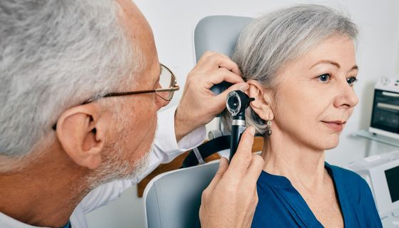 Ein Arzt untersucht das Ohr einer älteren Frau