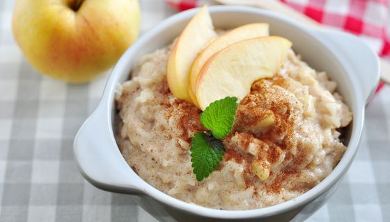 Schüssel mit Haferbrei und einem Apfel-Schnitz.