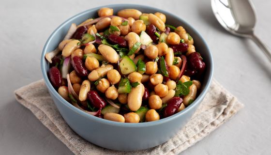 Schüssel mit Drei-Bohnen-Salat, daneben ein Löffel.
