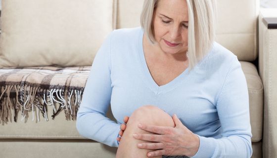 Frau über 50 Jahre hält sich das Knie