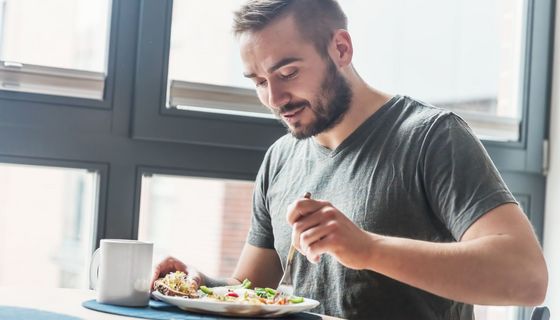Junger Mann frühstückt.