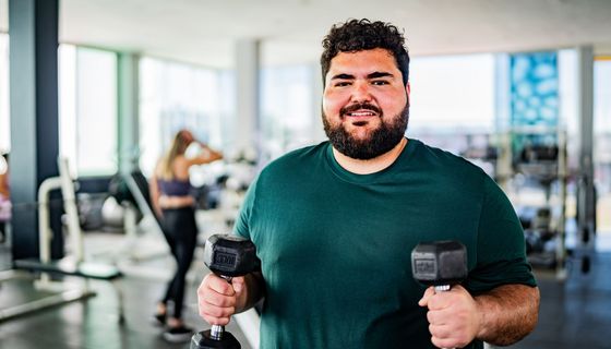 Übergewichtiger Mann im Fitnessstudio.