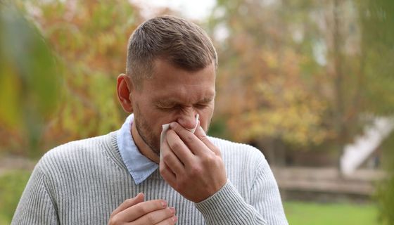 Mann niest im Stadtpark.