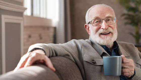 Älterer Mann trinkt eine Tasse Kaffee.