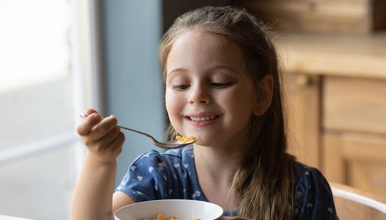 Kind, etwa fünf Jahre alt, isst Cornflakes.